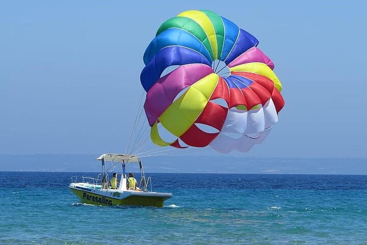 a colorful parachute flying over a boat in the ocean