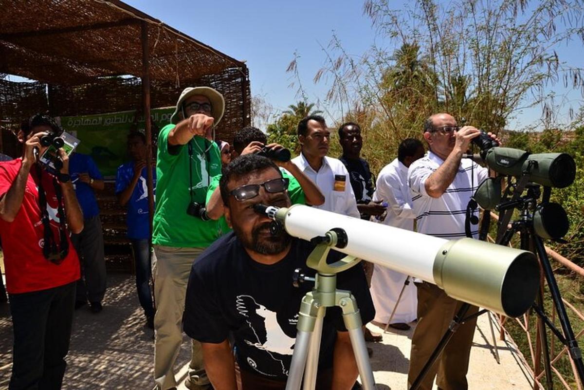 un gruppo di persone in piedi attorno a una telecamera