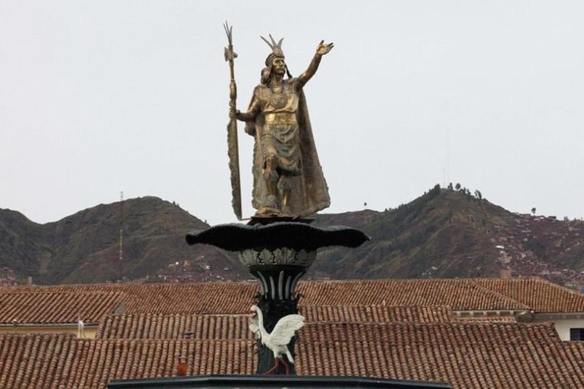 una statua di una donna che tiene una croce su un tetto