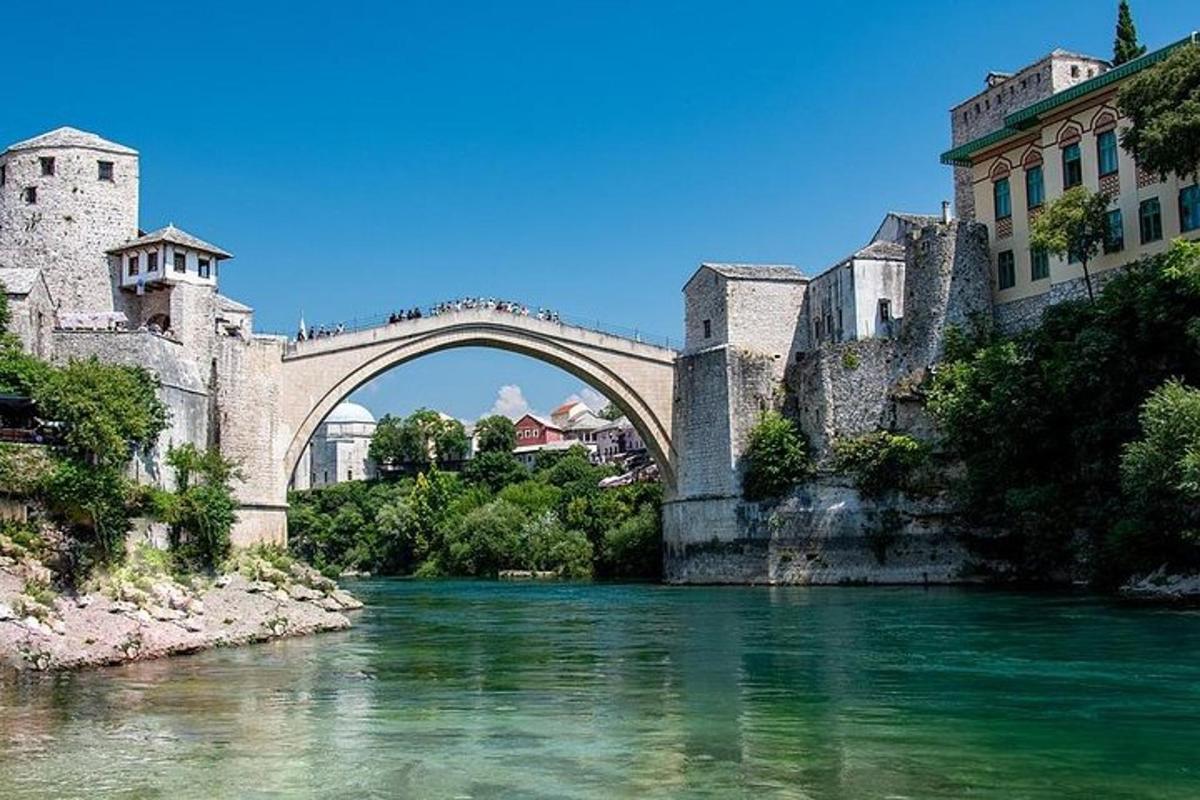 μια γέφυρα πάνω από ένα ποτάμι μπροστά από ένα κτίριο