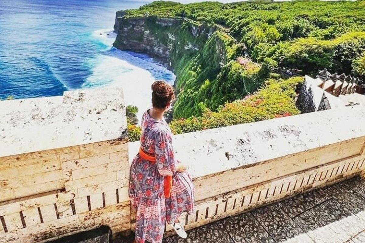 žena stojící na římse a dívající se na oceán