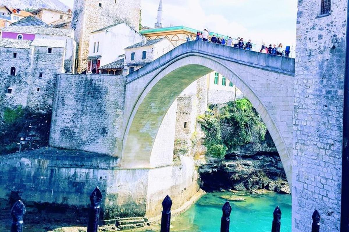 μια γέφυρα πάνω από ένα ποτάμι με μια ομάδα ανθρώπων πάνω της