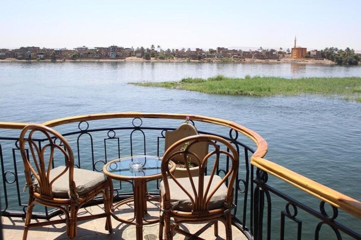 un balcone con due sedie e un tavolo e acqua