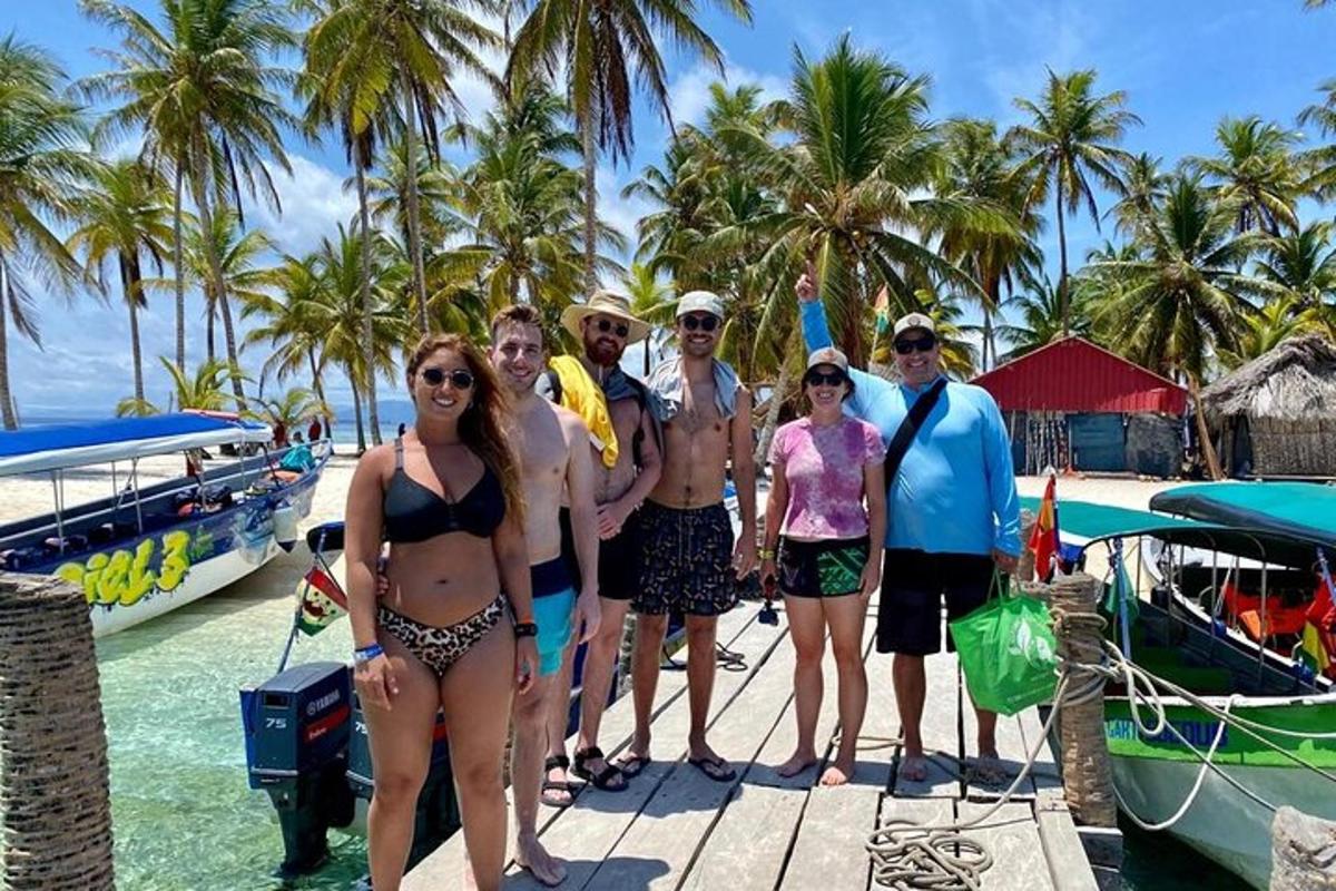 um grupo de pessoas em pé em uma doca ao lado de um barco
