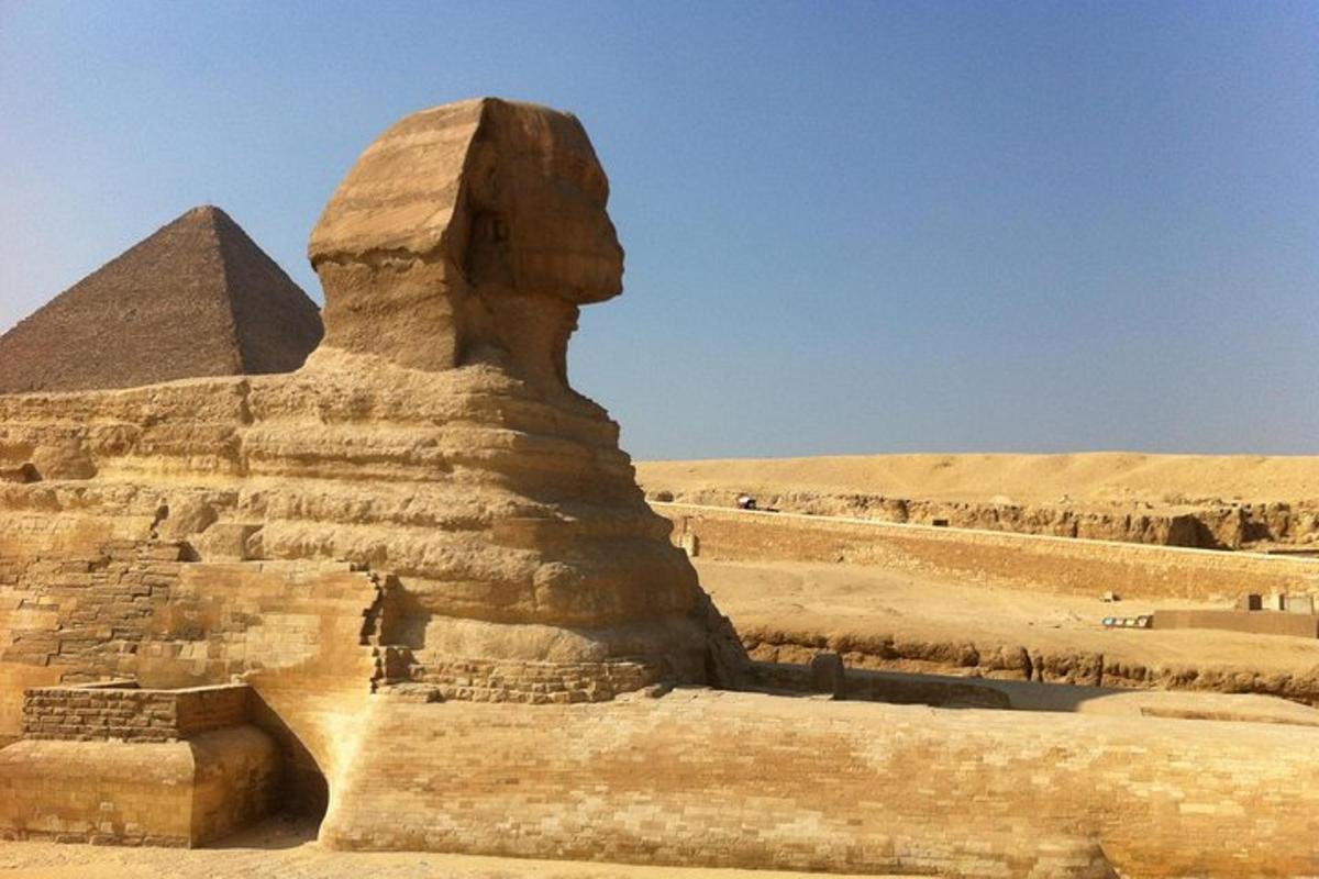 una statua di fronte alla sfinge e alla piramide