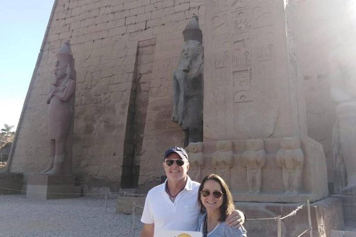 un uomo e una donna in piedi davanti a una statua