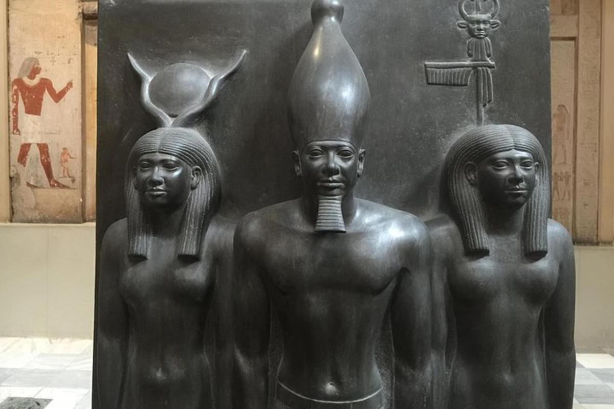 a statue of three people with a bottle on its back