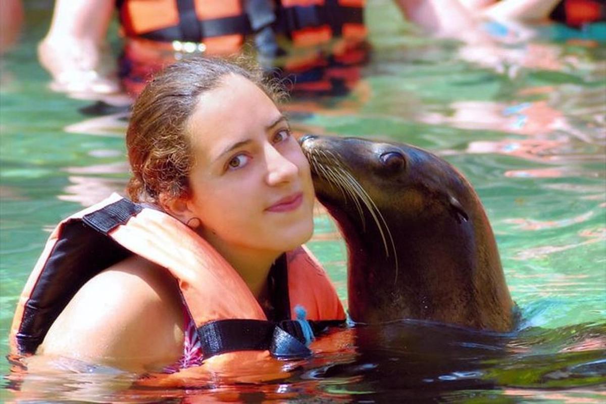 a woman swimming in the water with a sea animal