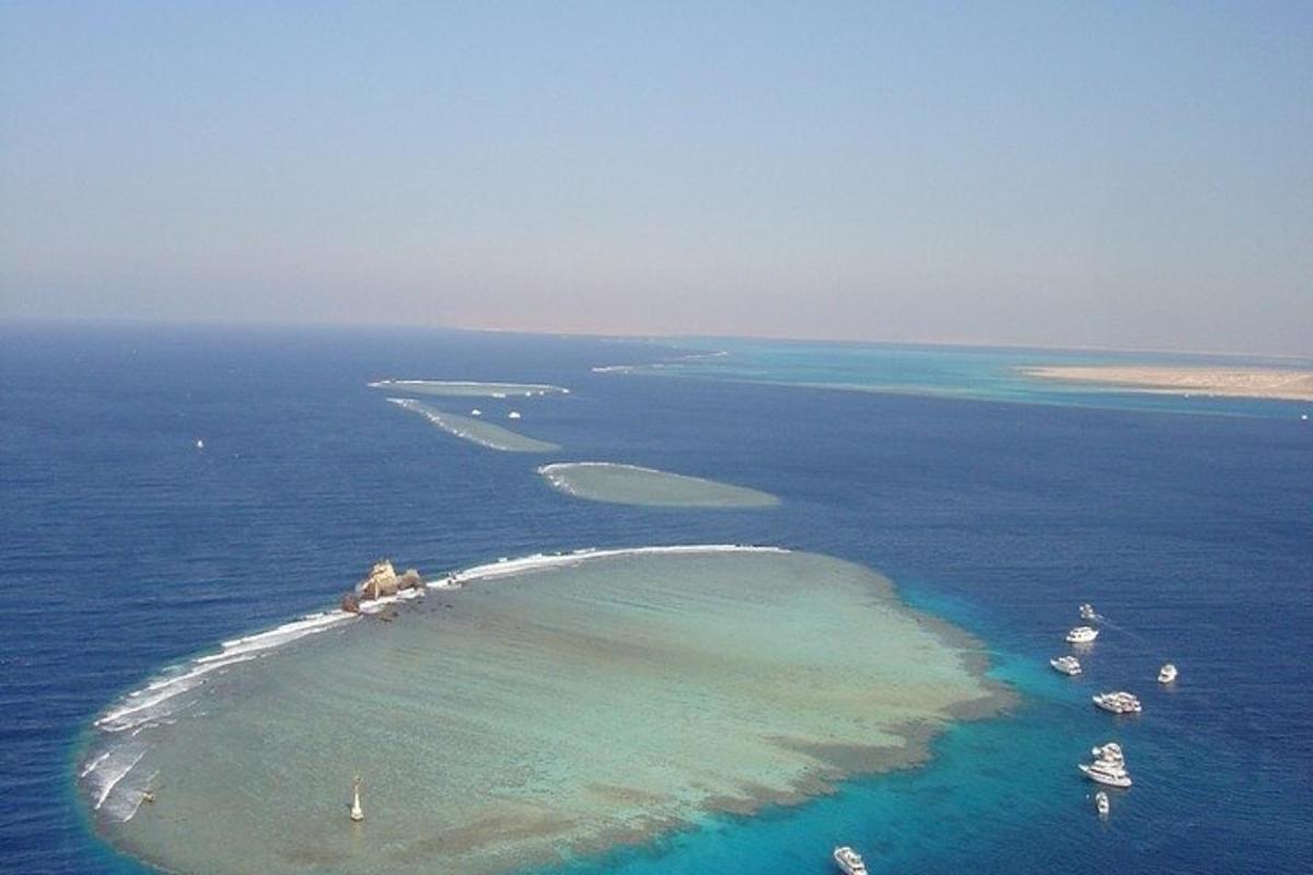 sebuah pulau di lautan dengan bot di dalam air