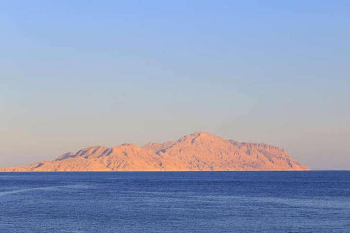 una montagna in mezzo a un grande specchio d'acqua