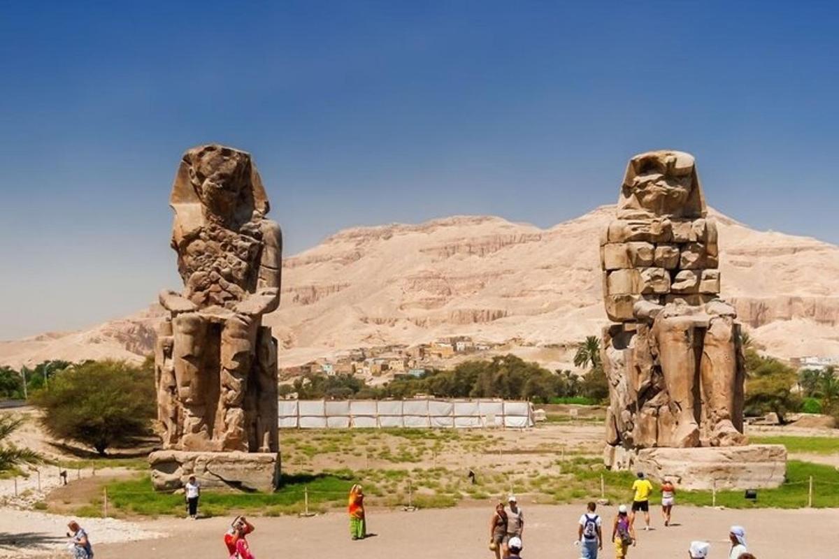 un gruppo di persone che camminano intorno a una statua nel deserto