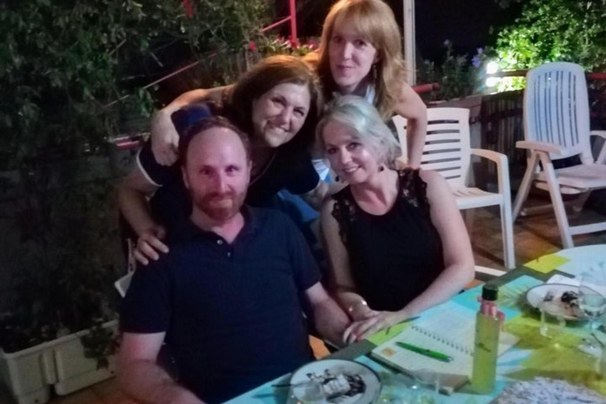 μια ομάδα ανθρώπων που ποζάρουν για μια φωτογραφία σε ένα τραπέζι