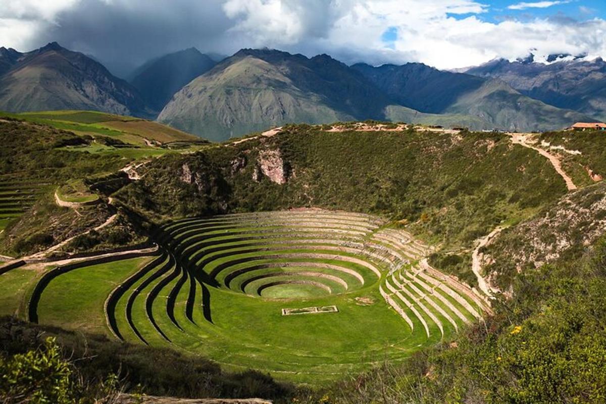 an amphitheater on a hill with mountains in the background
