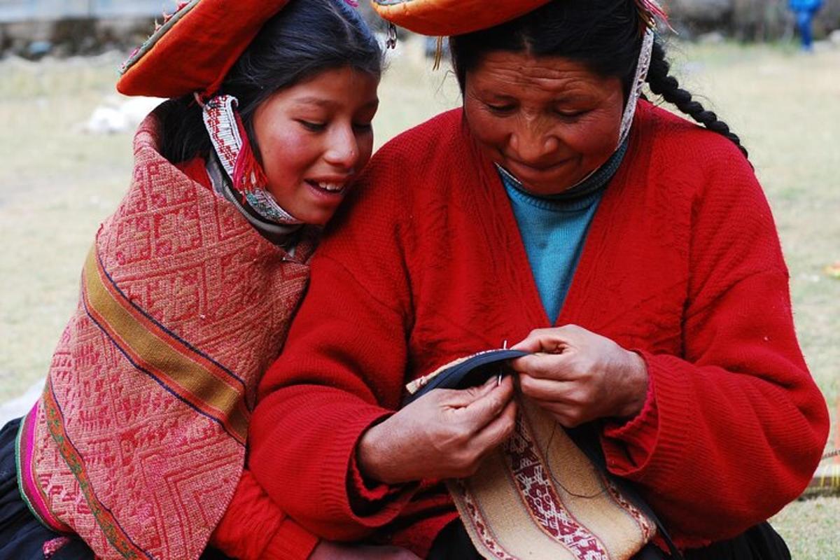 two women sitting next to each other looking at a cell phone