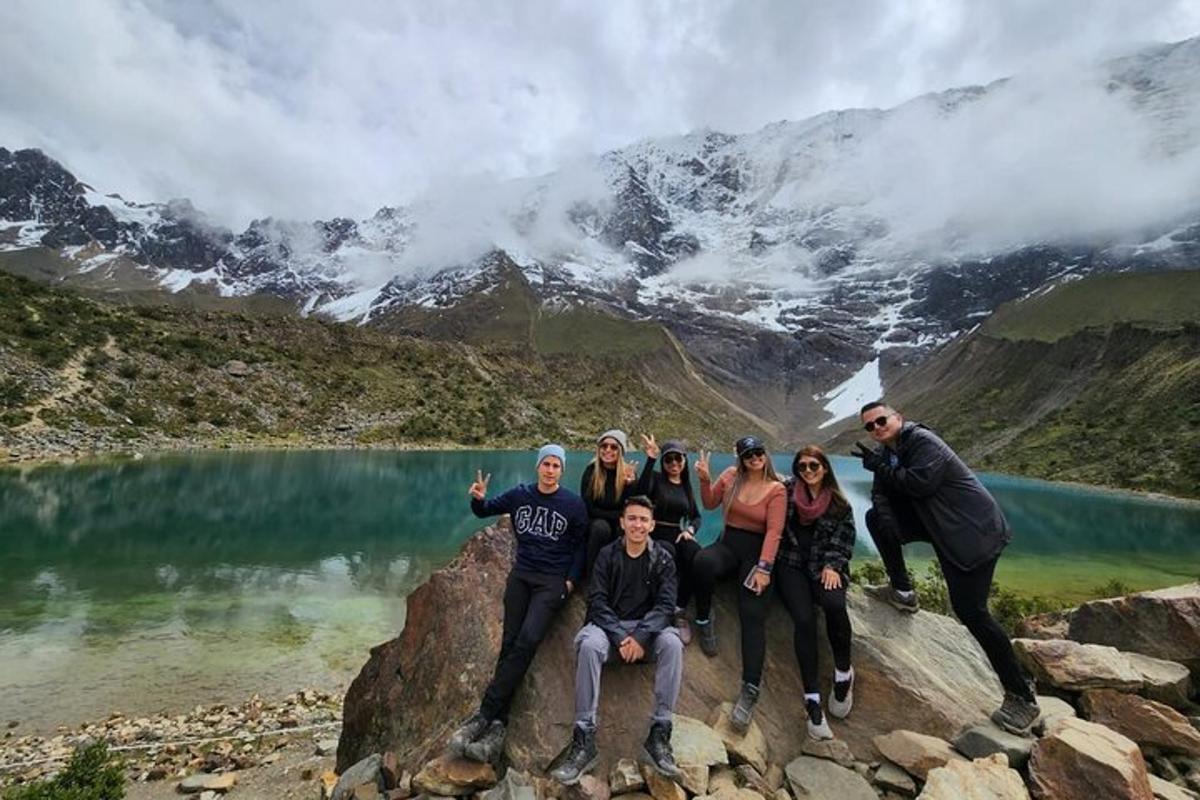 Un grupo de personas de pie sobre una roca cerca de un lago.