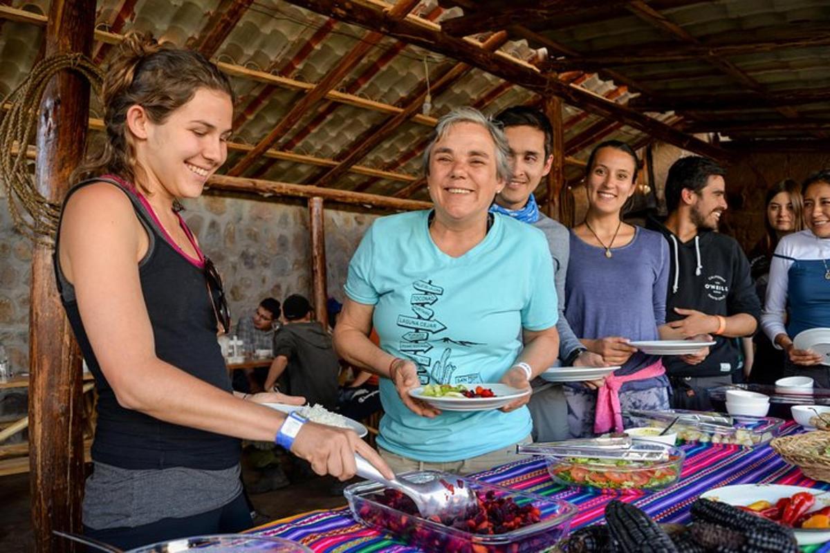 Un grupo de personas de pie alrededor de una mesa con platos de comida.