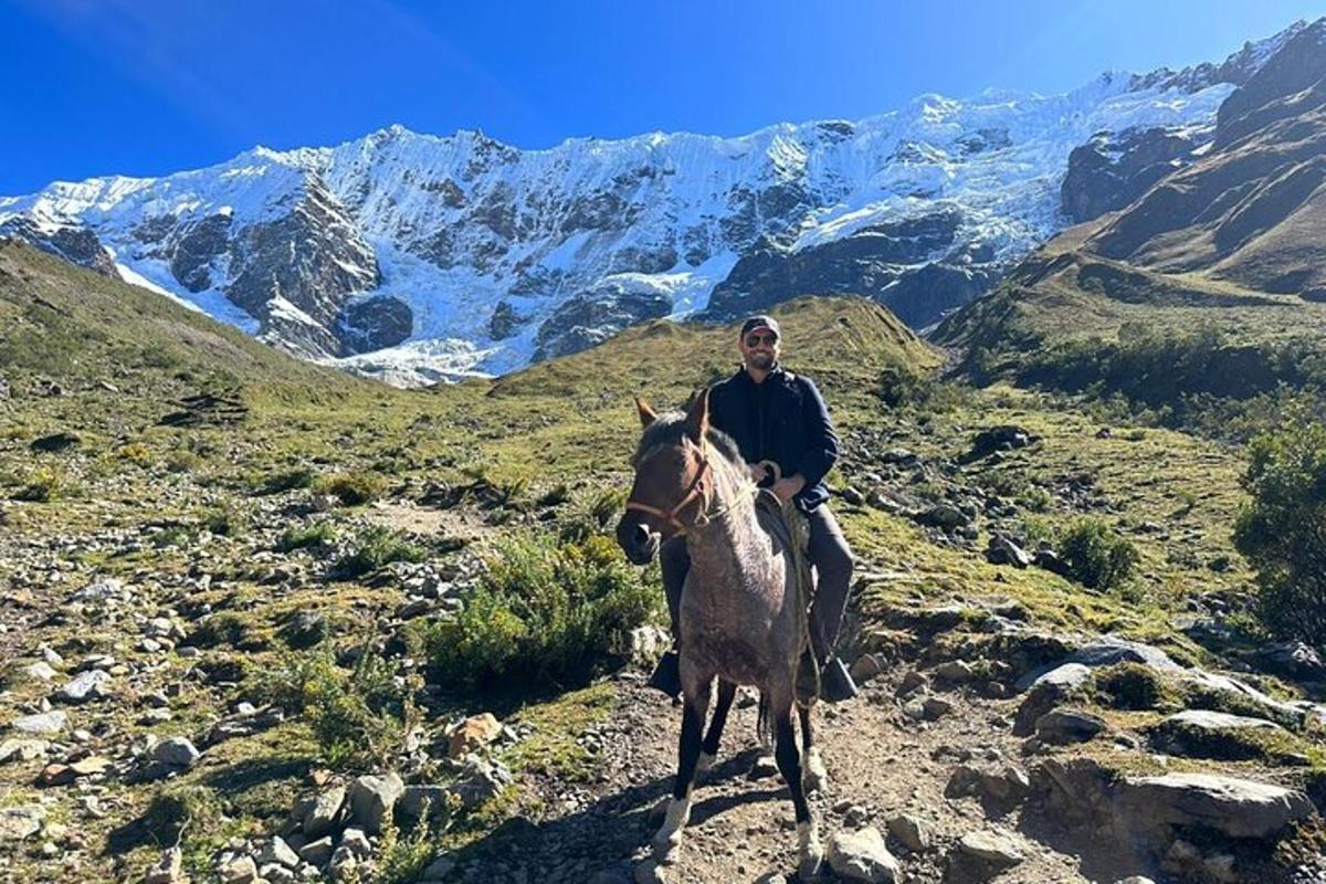 Un hombre está montando a caballo en una montaña