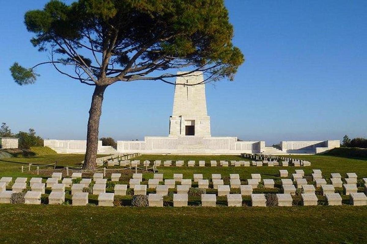 un monumento in un campo con un albero e dell'erba