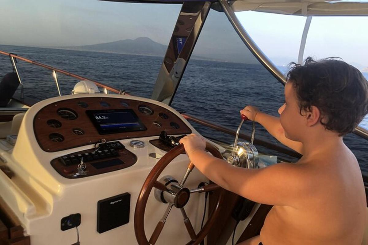 um menino dirigindo um barco no oceano