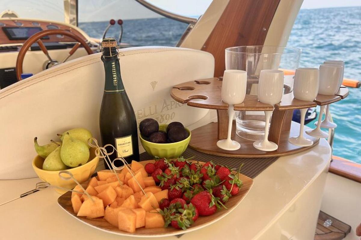 um prato de frutas e uma garrafa de vinho em um barco