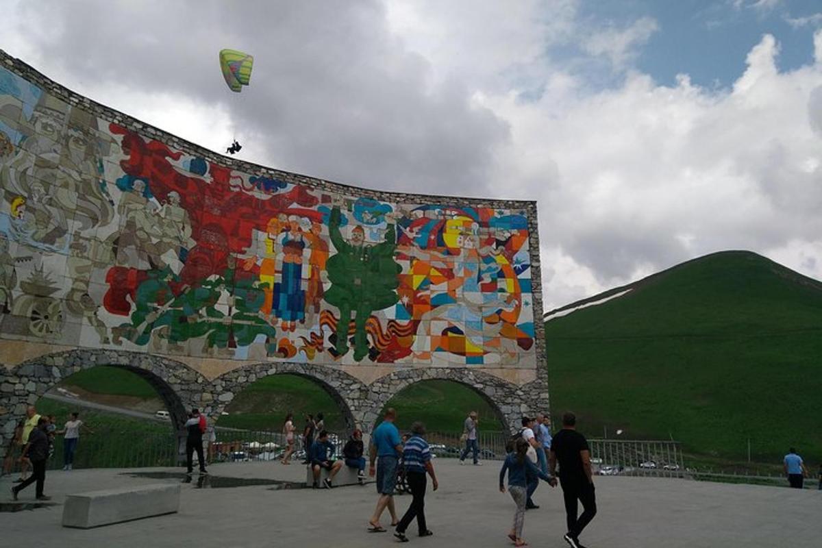 a group of people walking in front of a large mural