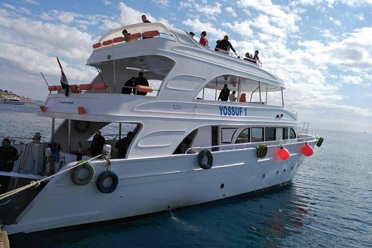 isang puting bangka sa tubig na may mga tao sa ibabaw nito