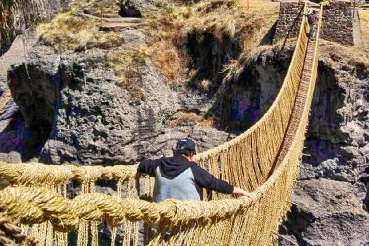 un uomo che attraversa un ponte sospeso sopra un canyon