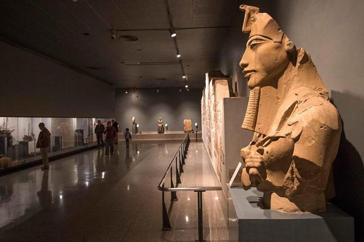 a statue in a museum with people standing around it