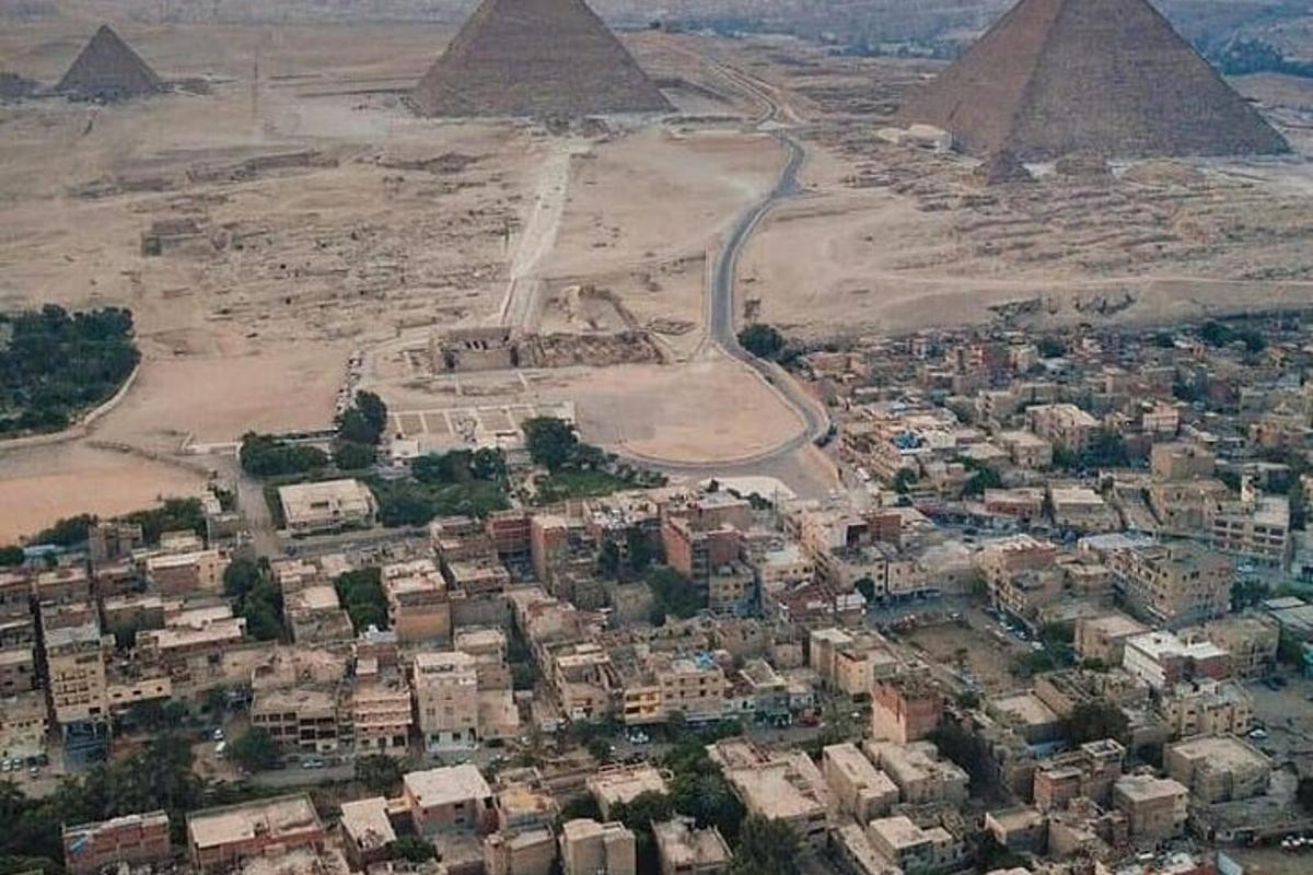 Letecký pohled na město s pyramidami v pozadí