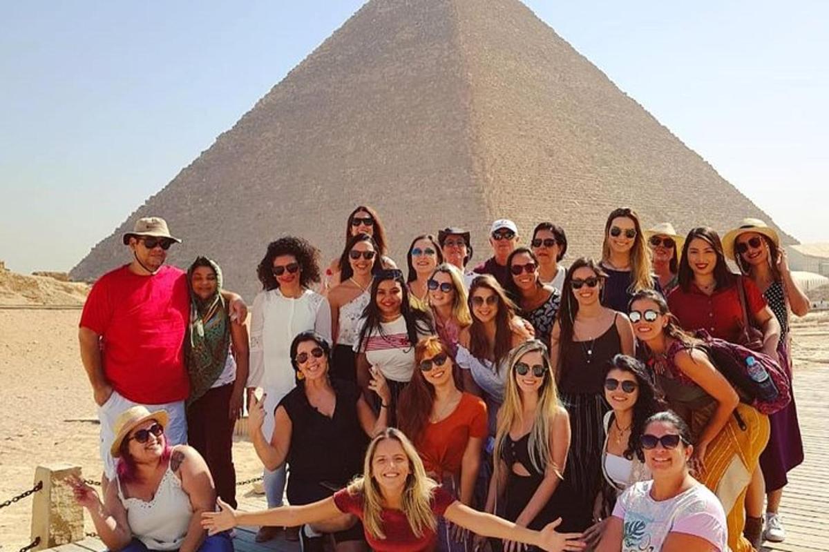 skupina lidí pózujících před pyramidou