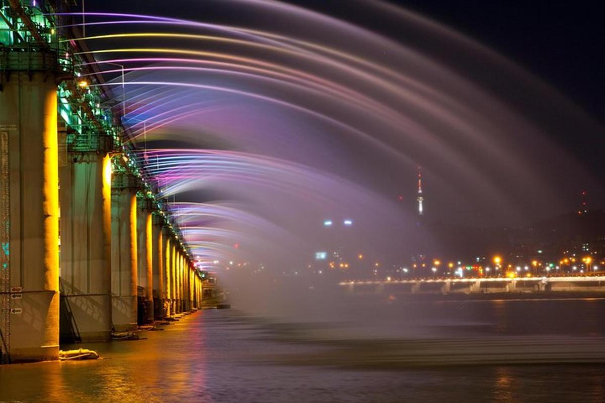 un lungo ponte con luci sull'acqua di notte