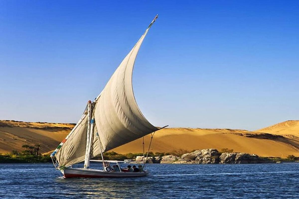 um barco com uma vela branca em um corpo d'água