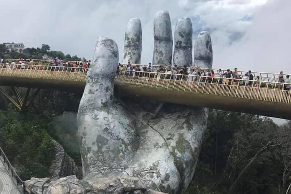 a bridge with a giant hand on a rock