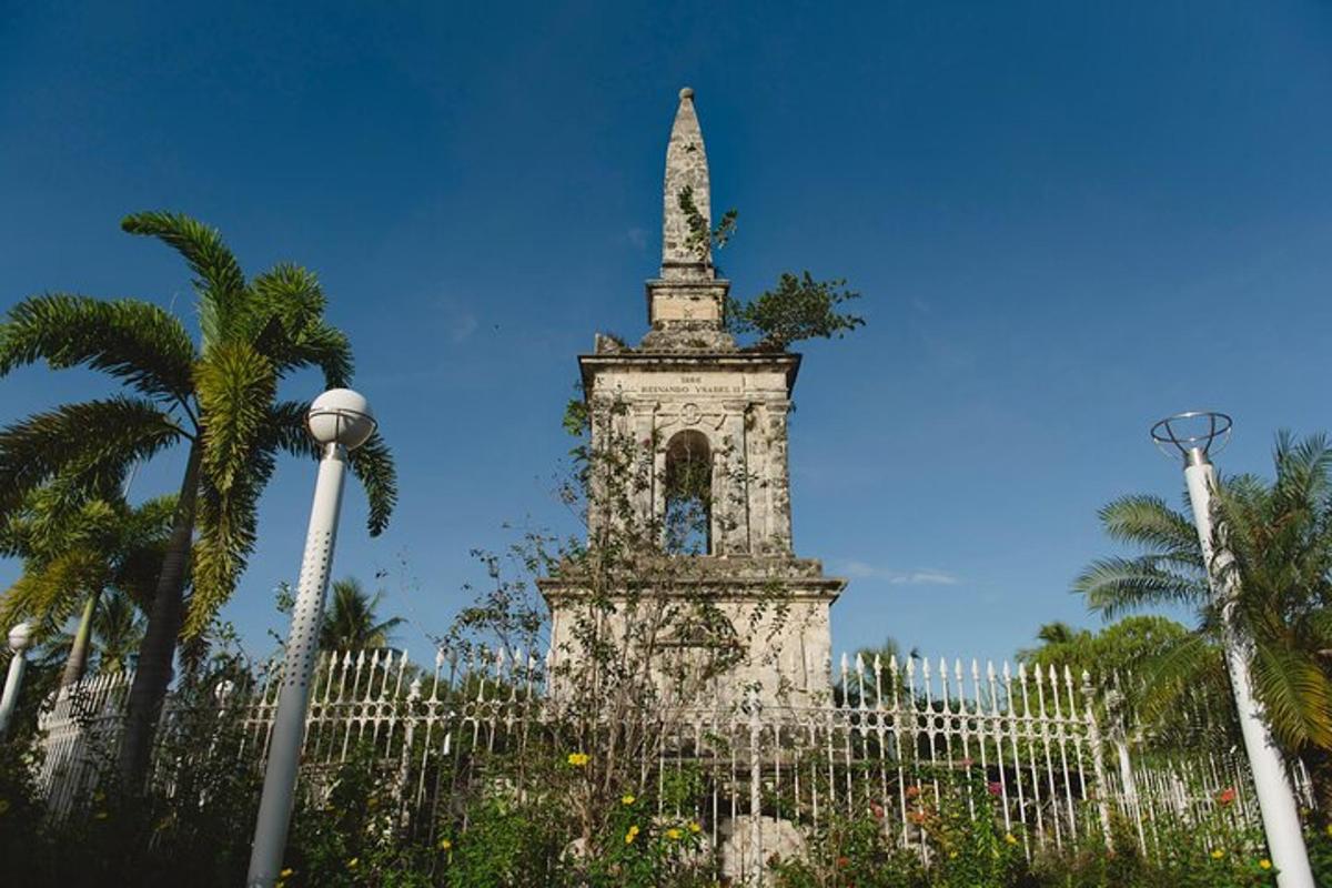 una torre alta con una estatua en la cima