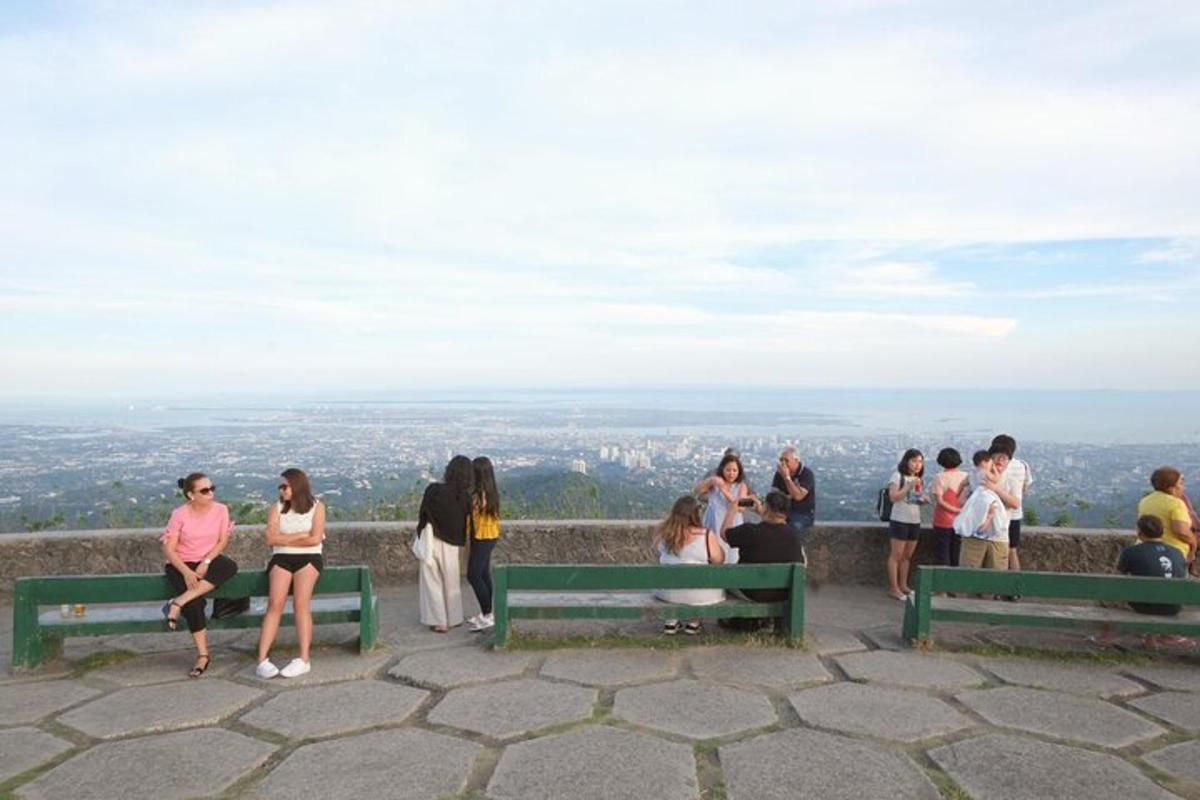 a group of people sitting on benches on a hill