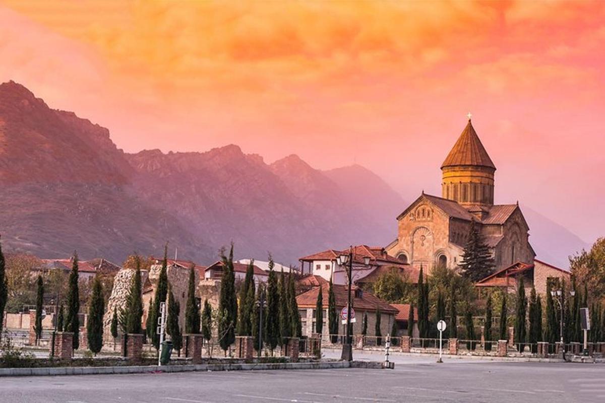 μια εκκλησία με πύργο μπροστά σε ένα βουνό