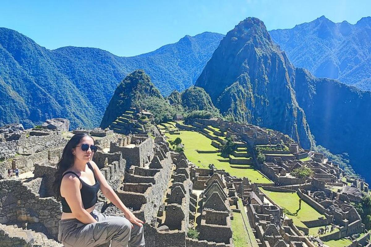 a woman sitting on the edge of an ancient ruins