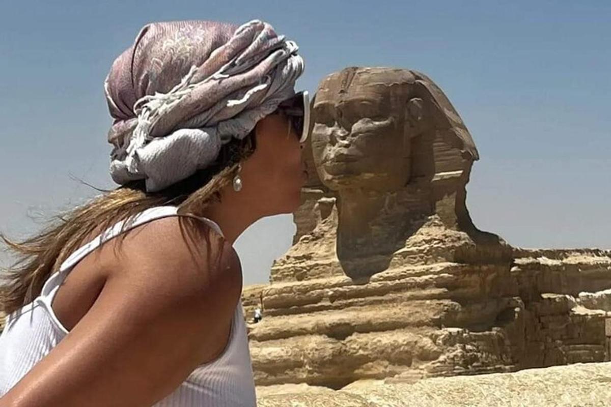 seorang wanita berhias berdiri di sebelah patung