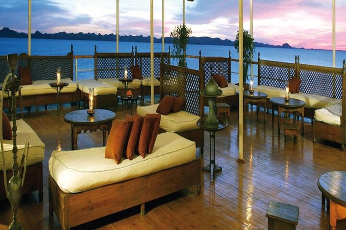 ร้านอาหารที่มีโต๊ะและโซฟาบนระเบียง