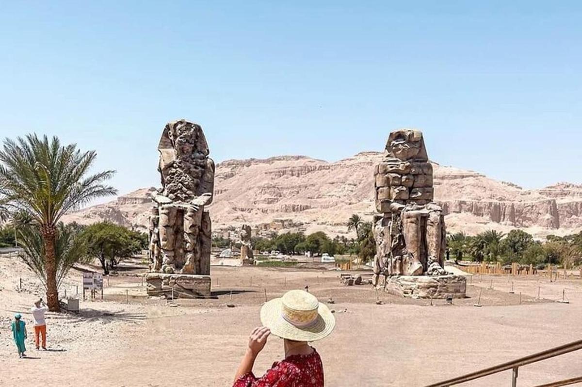 امرأة ترتدي قبعة وتجلس أمام تمثال