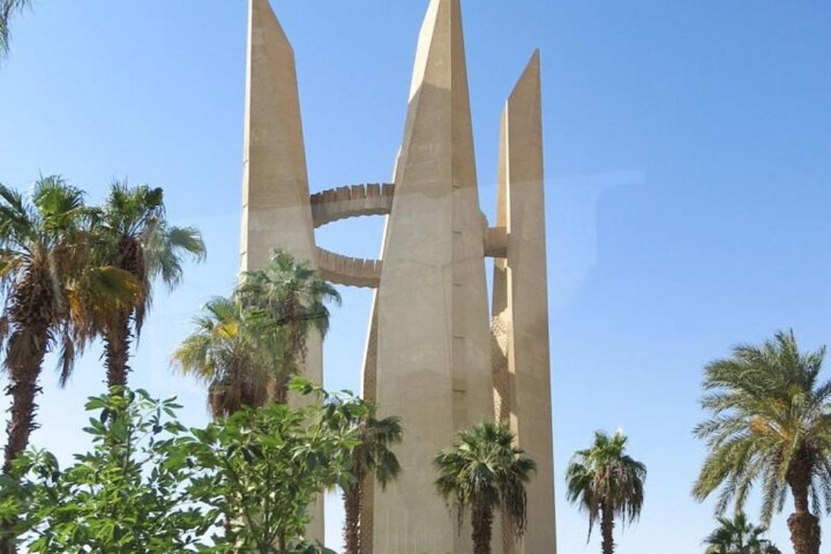 um monumento com palmeiras em frente a um céu azul