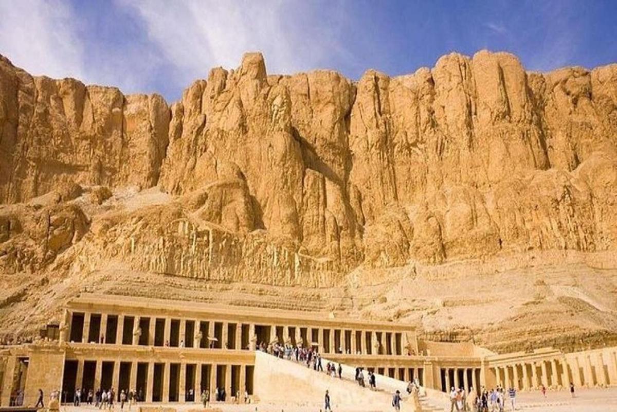 un edificio di fronte a una montagna con persone in piedi fuori