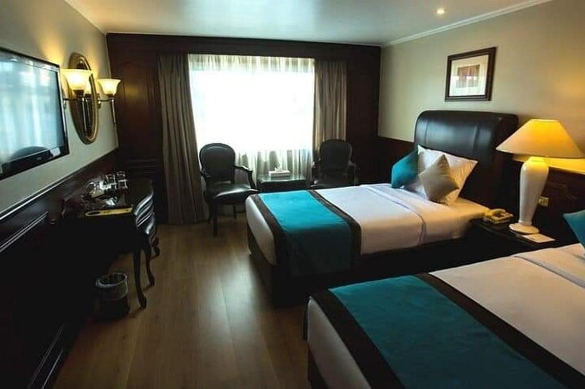 um quarto de hotel com duas camas e uma televisão