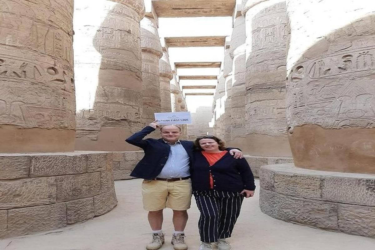 um homem e uma mulher segurando uma placa em um templo