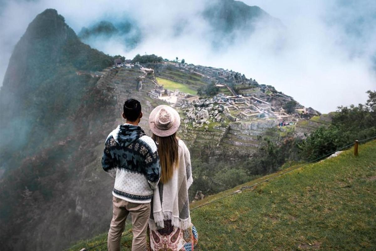 um homem e uma mulher em pé no topo de uma montanha