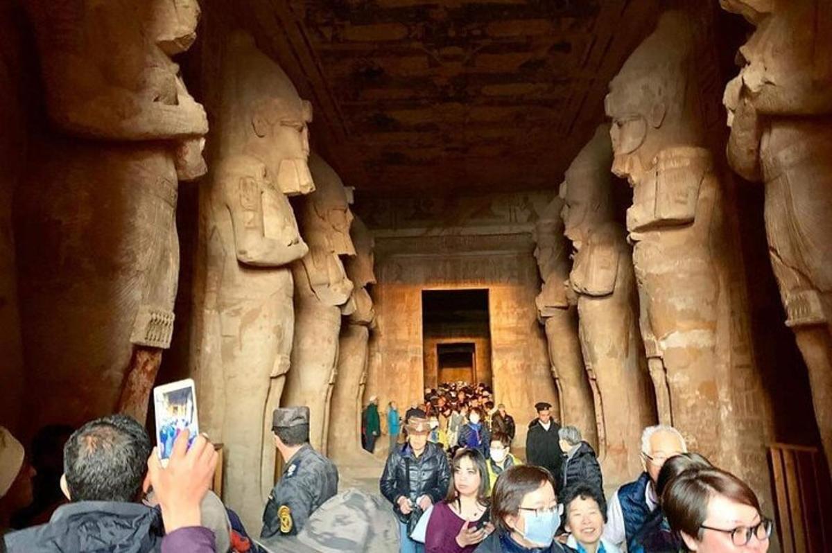 un gruppo di persone in piedi in una stanza con delle statue