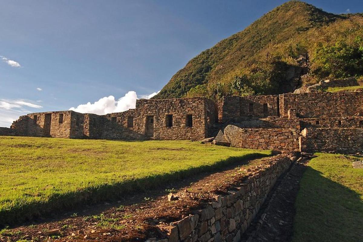 un vecchio edificio in un campo vicino a una montagna
