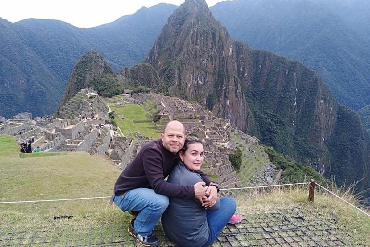 um homem e uma mulher sentados no topo de uma montanha