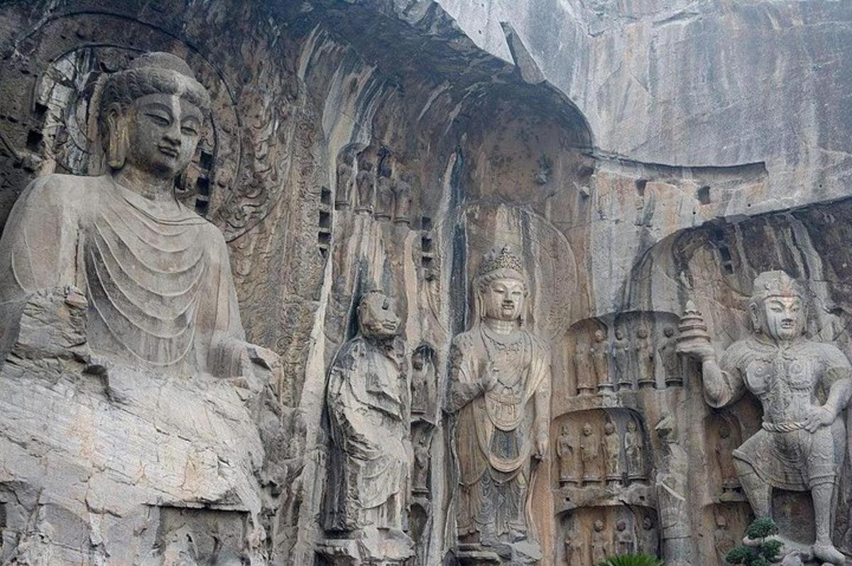 Un muro de piedra con estatuas de personas en él.