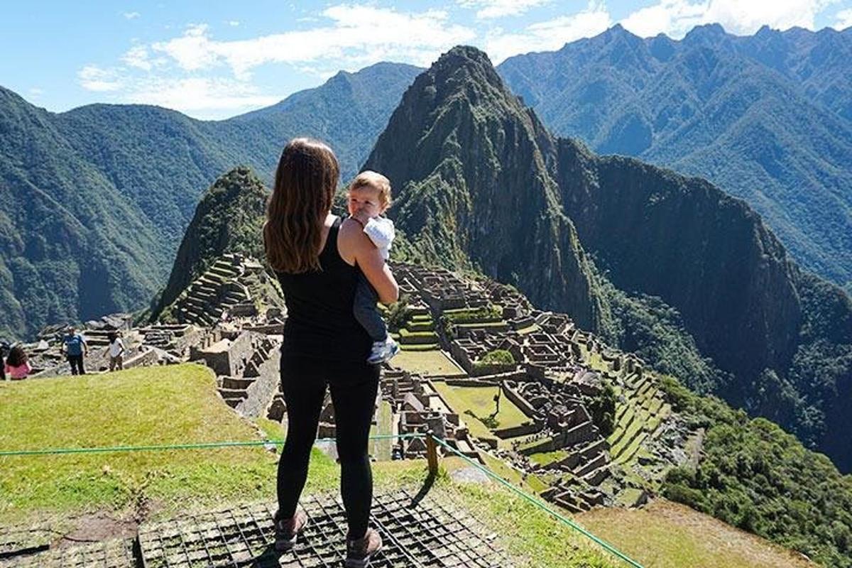 uma mulher segurando uma criança no topo de uma montanha